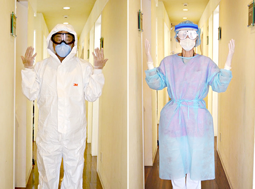 当医院スタッフがゴーグル、帽子、N95 マスク、感染予防着を着用している様子